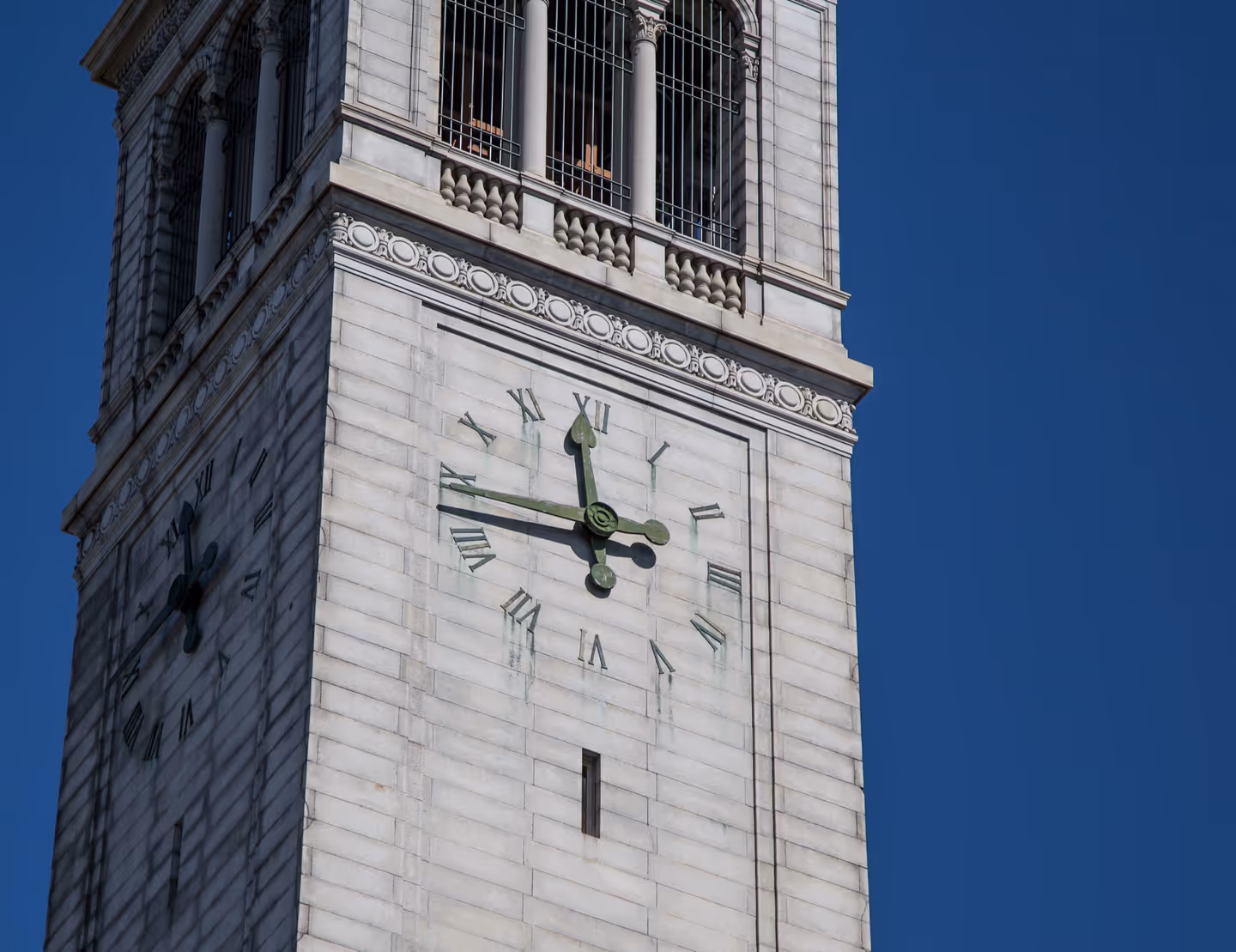 The clock face of Sather Tower against a clear sky